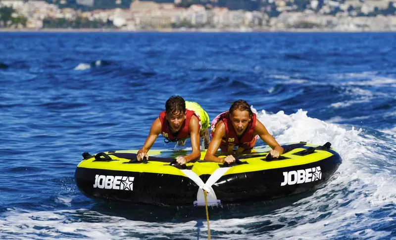 Groupe d’amis sur une bouée tractée Jobe lors d’un enterrement de vie de garçon à Cannes