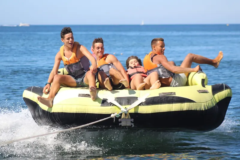 Canapé tracté gonflable avec quatre passagers hilares sur la Méditerranée