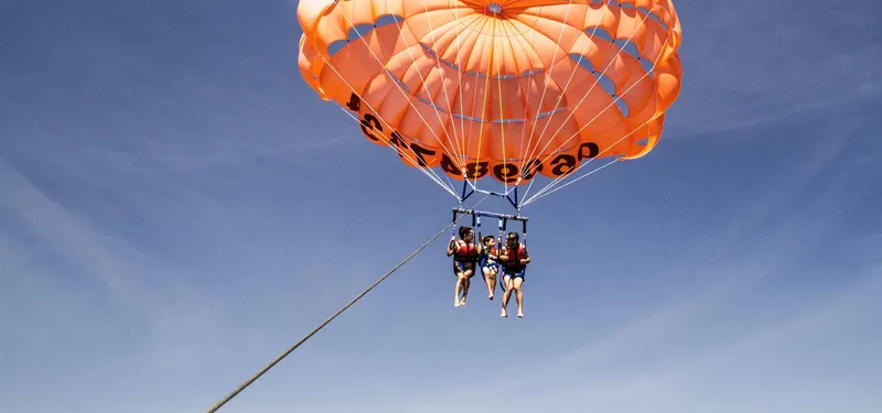 Parachute ascensionnel orange en vol au-dessus de la baie de Cannes et de Mandelieu