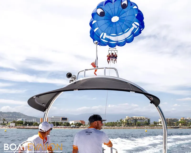 Voile bleue du parachute ascensionnel gonflée au-dessus du bateau dans la baie de Cannes