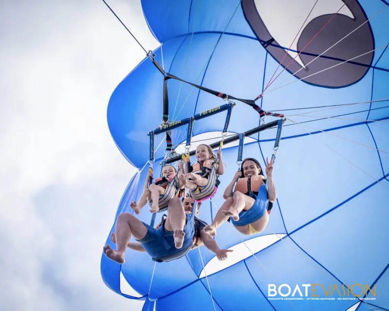 Quatre amis suspendus sous la grande voile bleue du parachute ascensionnel à Cannes